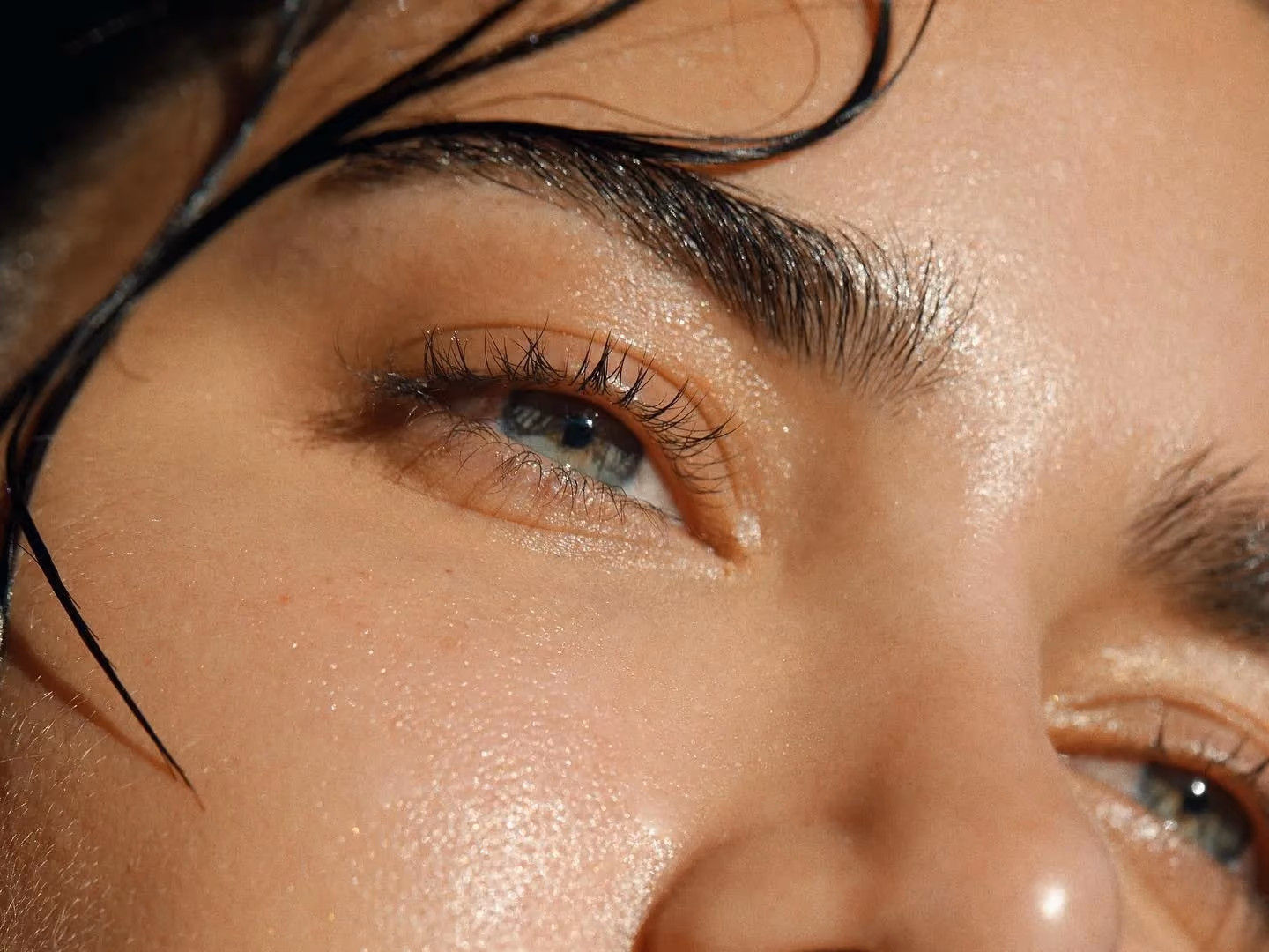 Close-up of a woman's eye and brow, the skin looking hydrated and luminous.